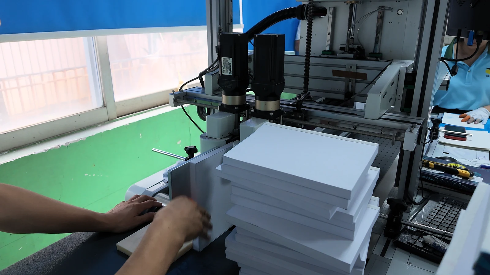 White book blocks being positioned at a machine station.