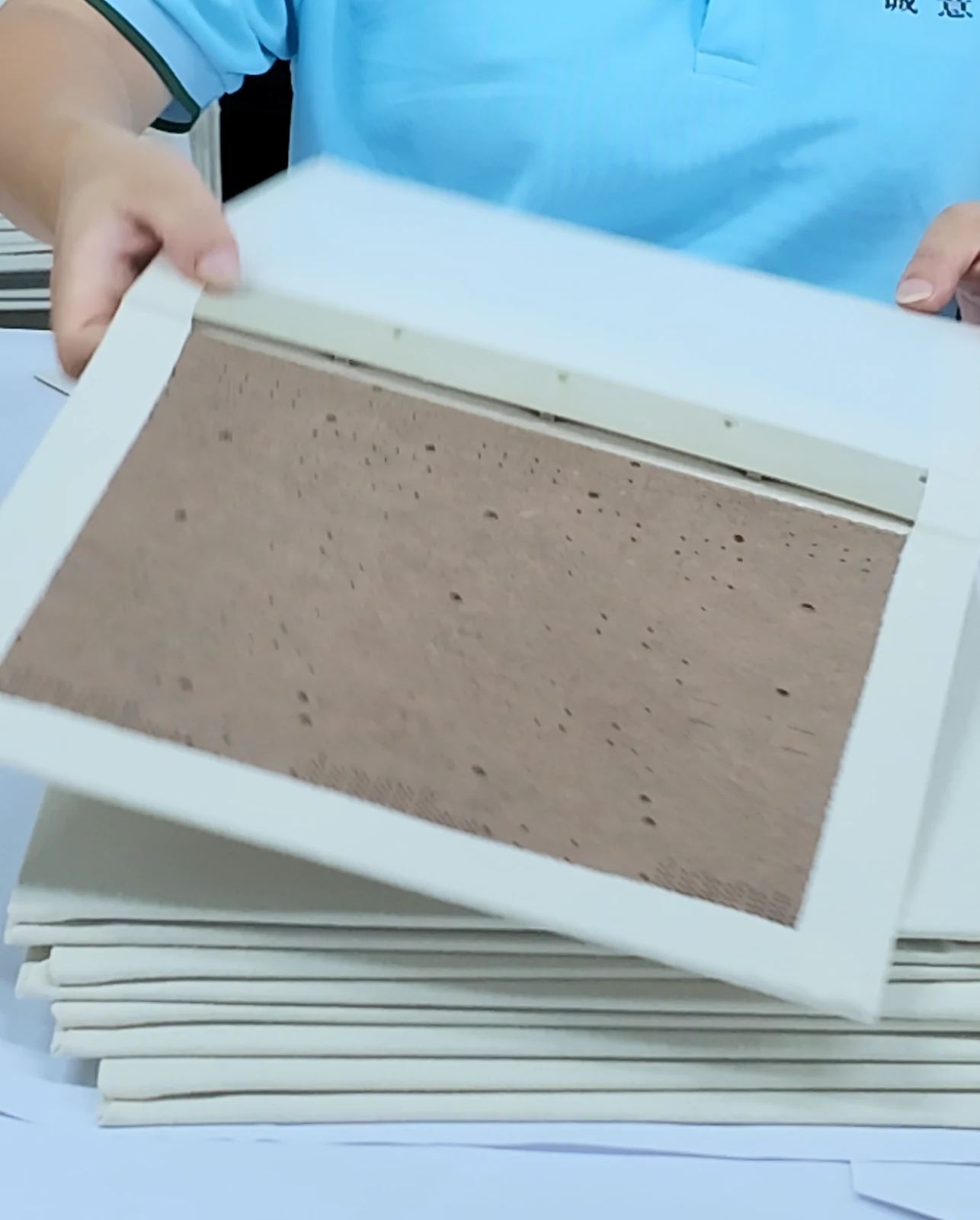A wrapped board component with its exposed interior and folded edges.