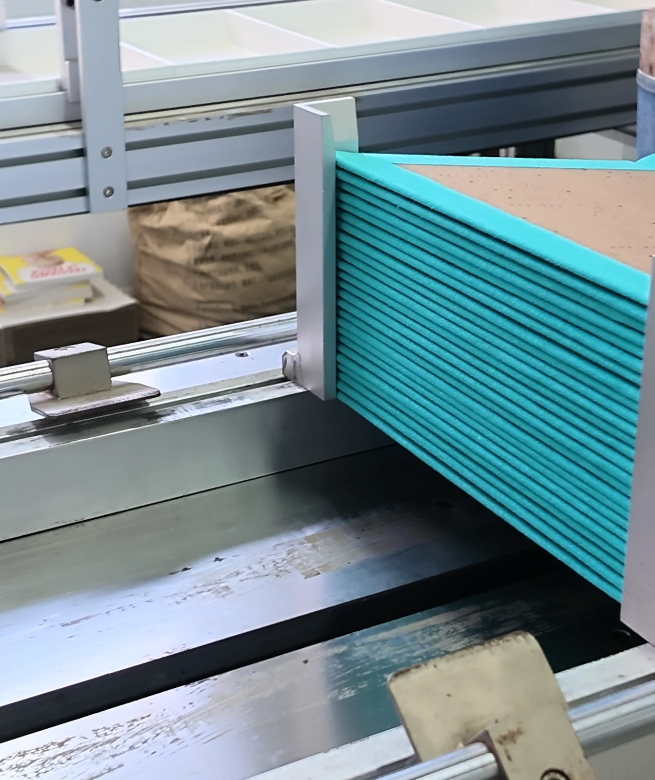 Wrapped case boards stacked beside the machine feed guides.