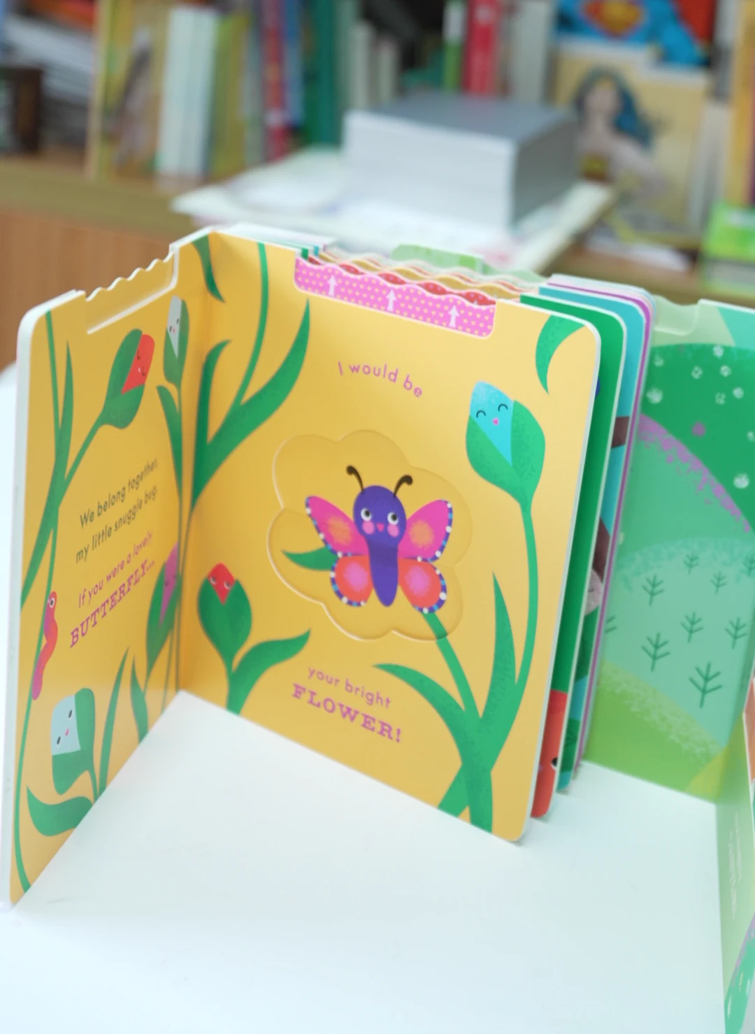 An open board-book sample with rounded page corners and movable paper elements.