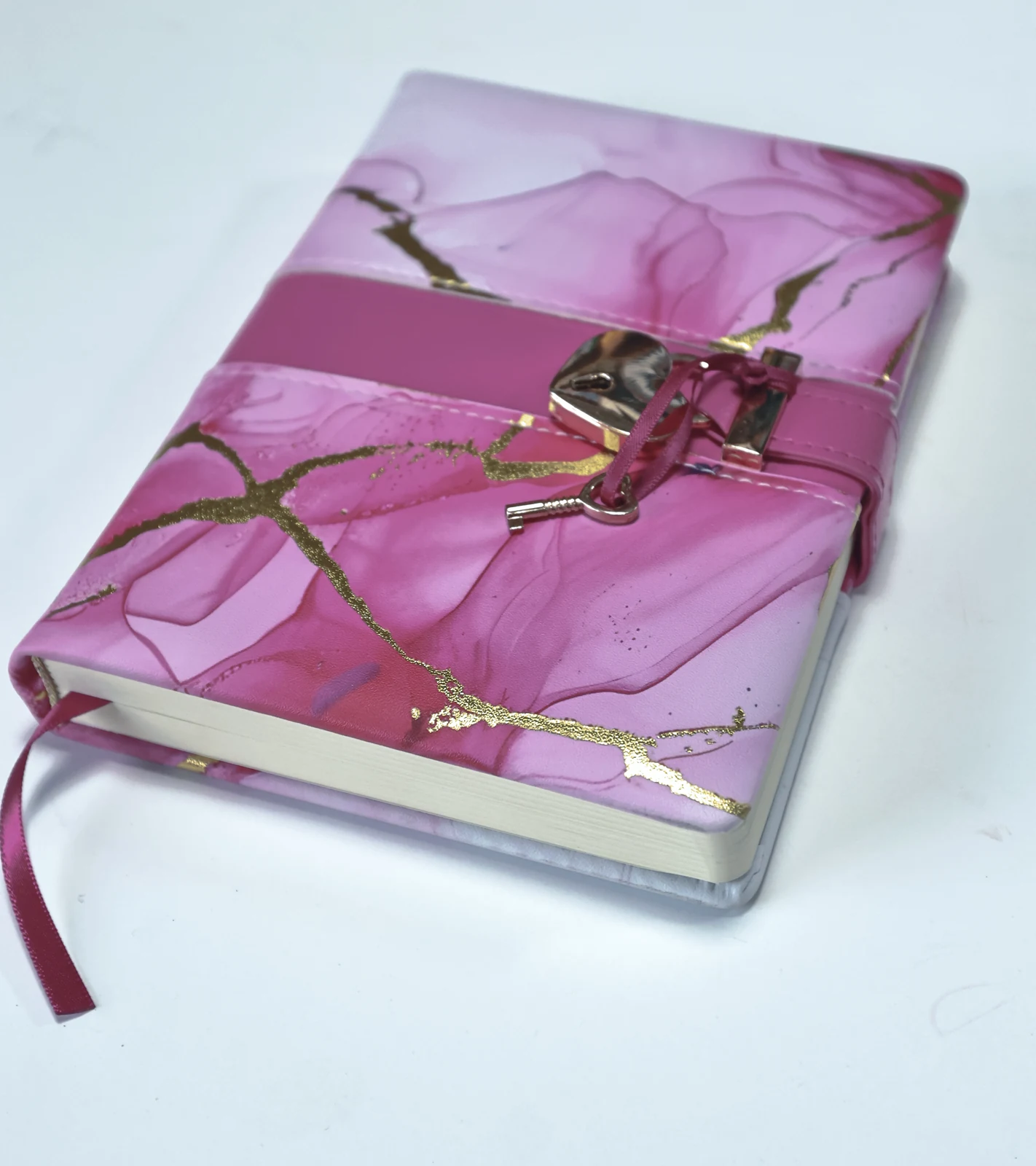 Decorative journal with metallic cover accents, a ribbon and a lock closure.