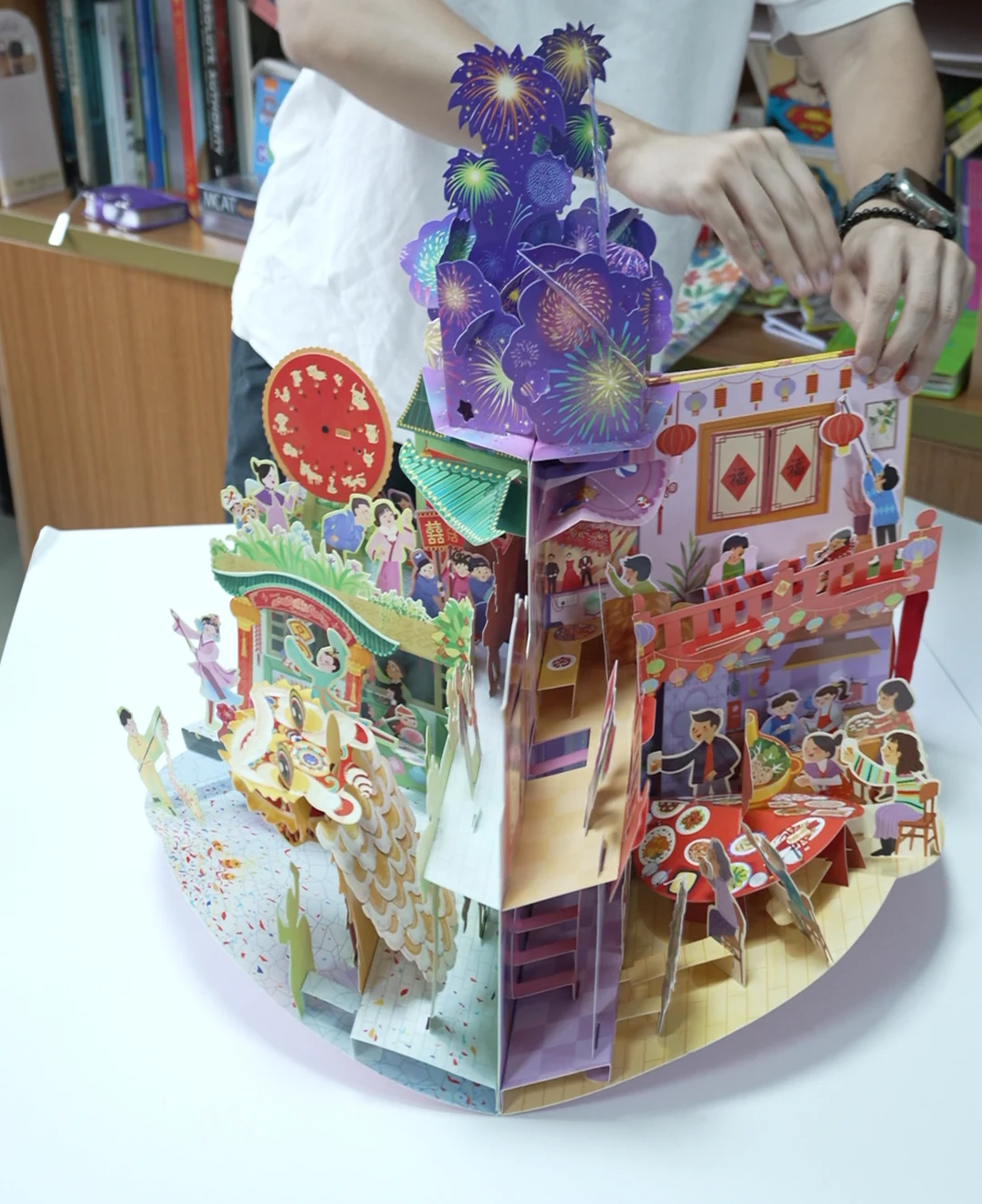 An opened carousel-style book with several connected paper scenes.