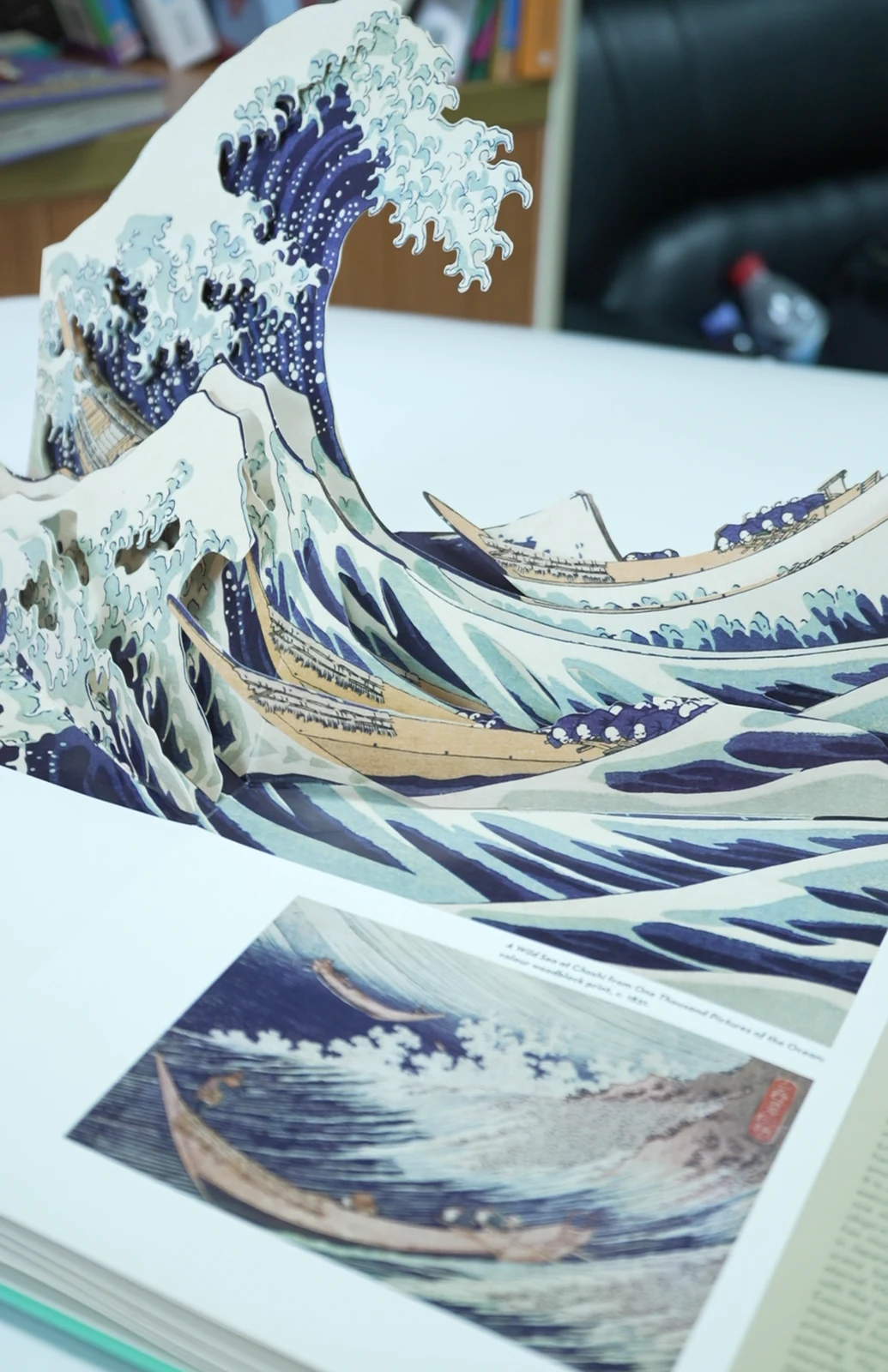 An expanded pop-up spread with layered wave-shaped paper elements.